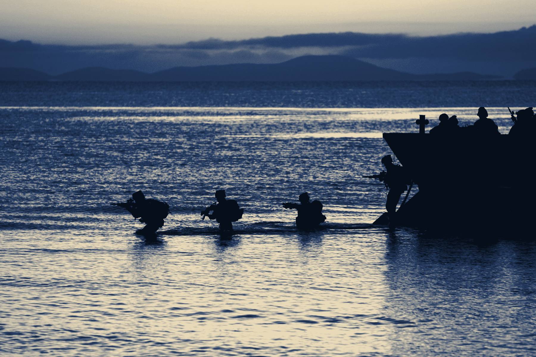 Marines wading ashore from a landing craft at first light