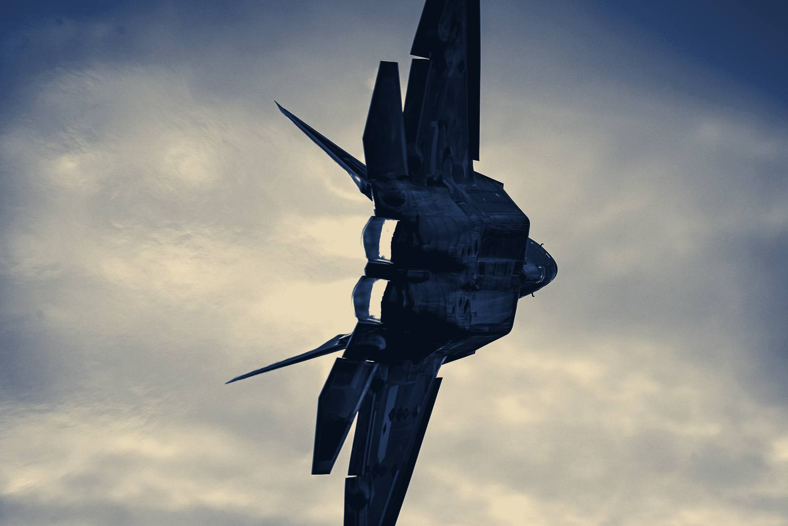 An F-22 Raptor banking hard, afterburners lit